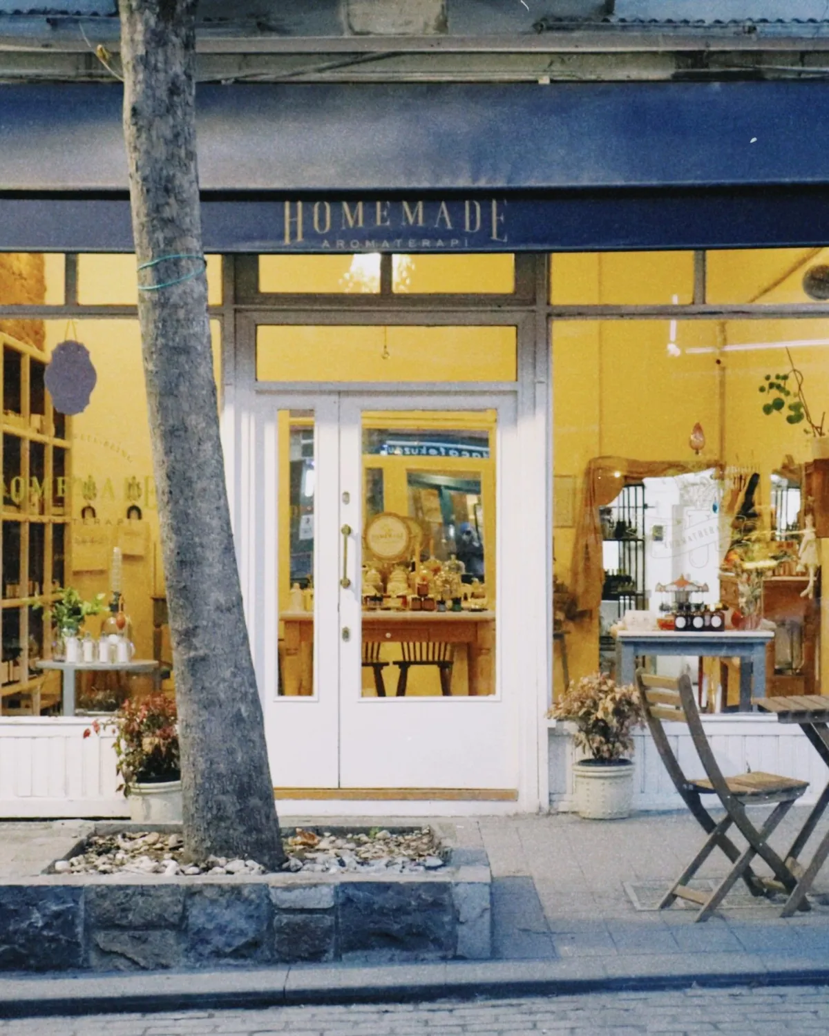 A small independent storefront with an awning on a quiet street