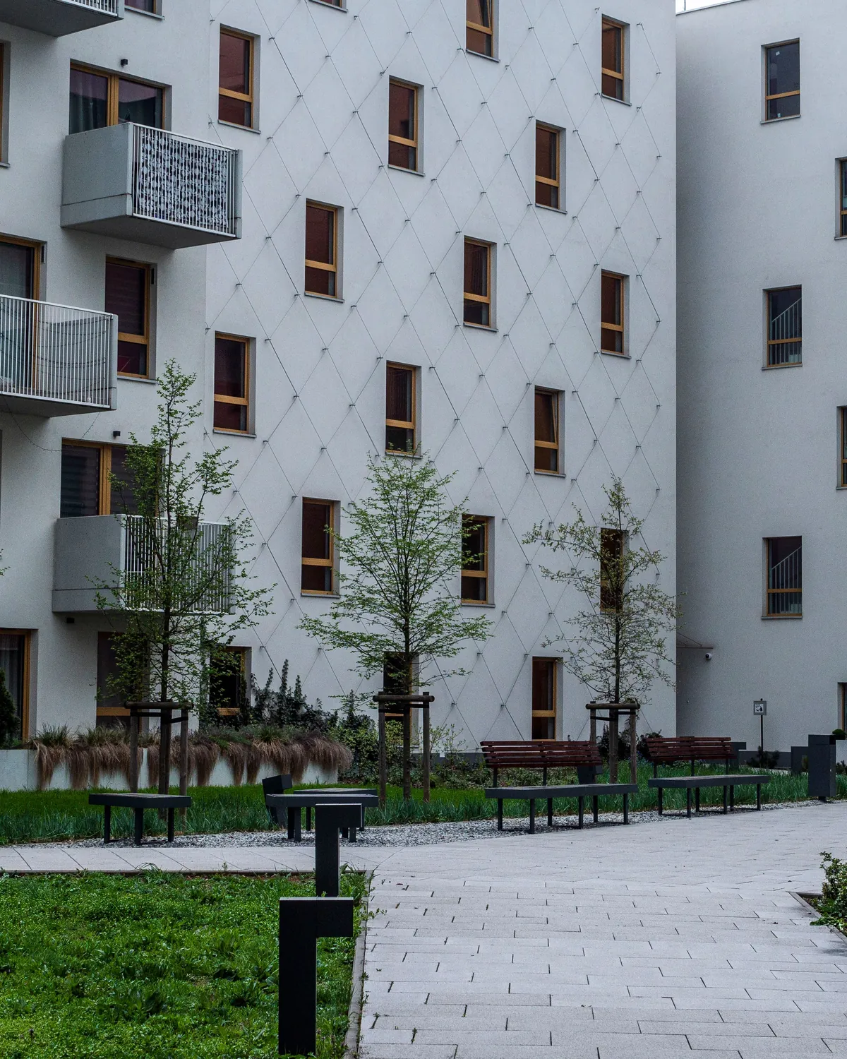 A modern low-rise apartment building with a landscaped courtyard
