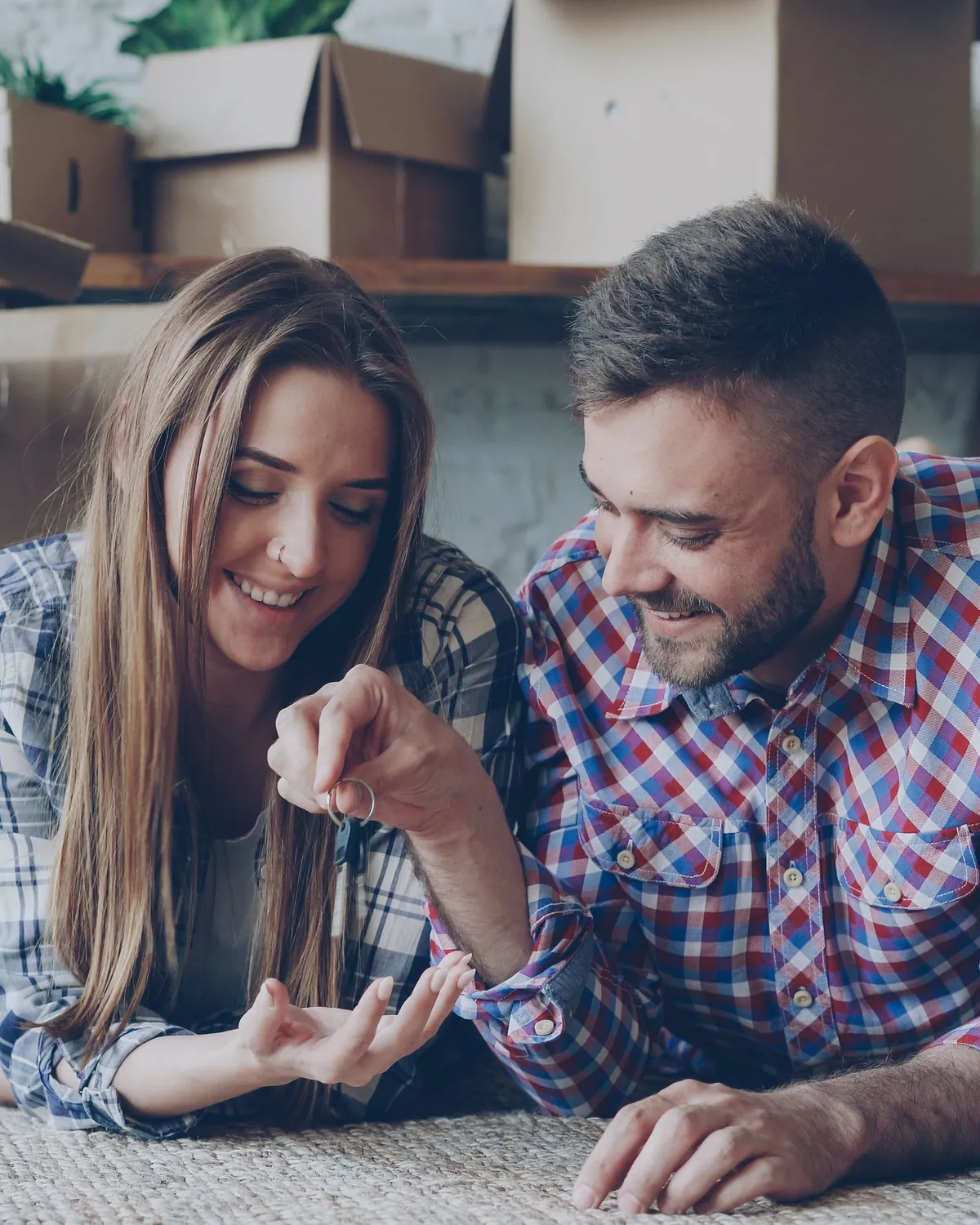 A couple sitting on the floor among moving boxes