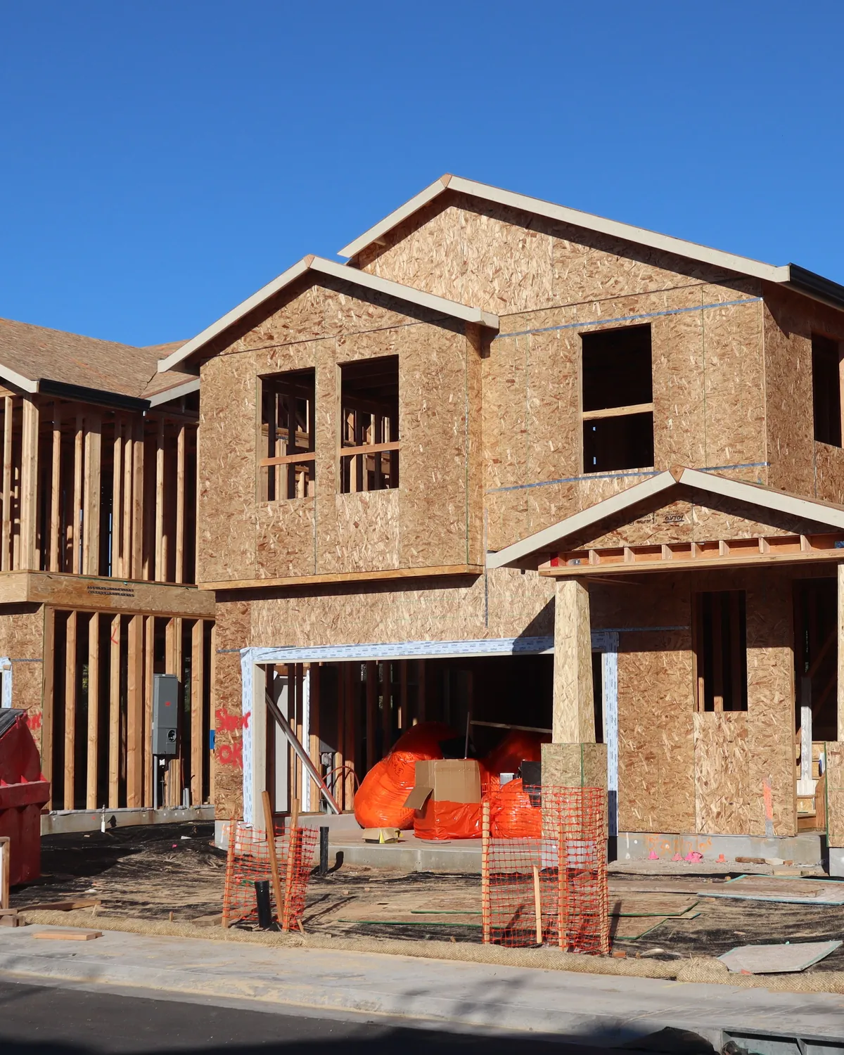 A two-storey house under construction, framing exposed